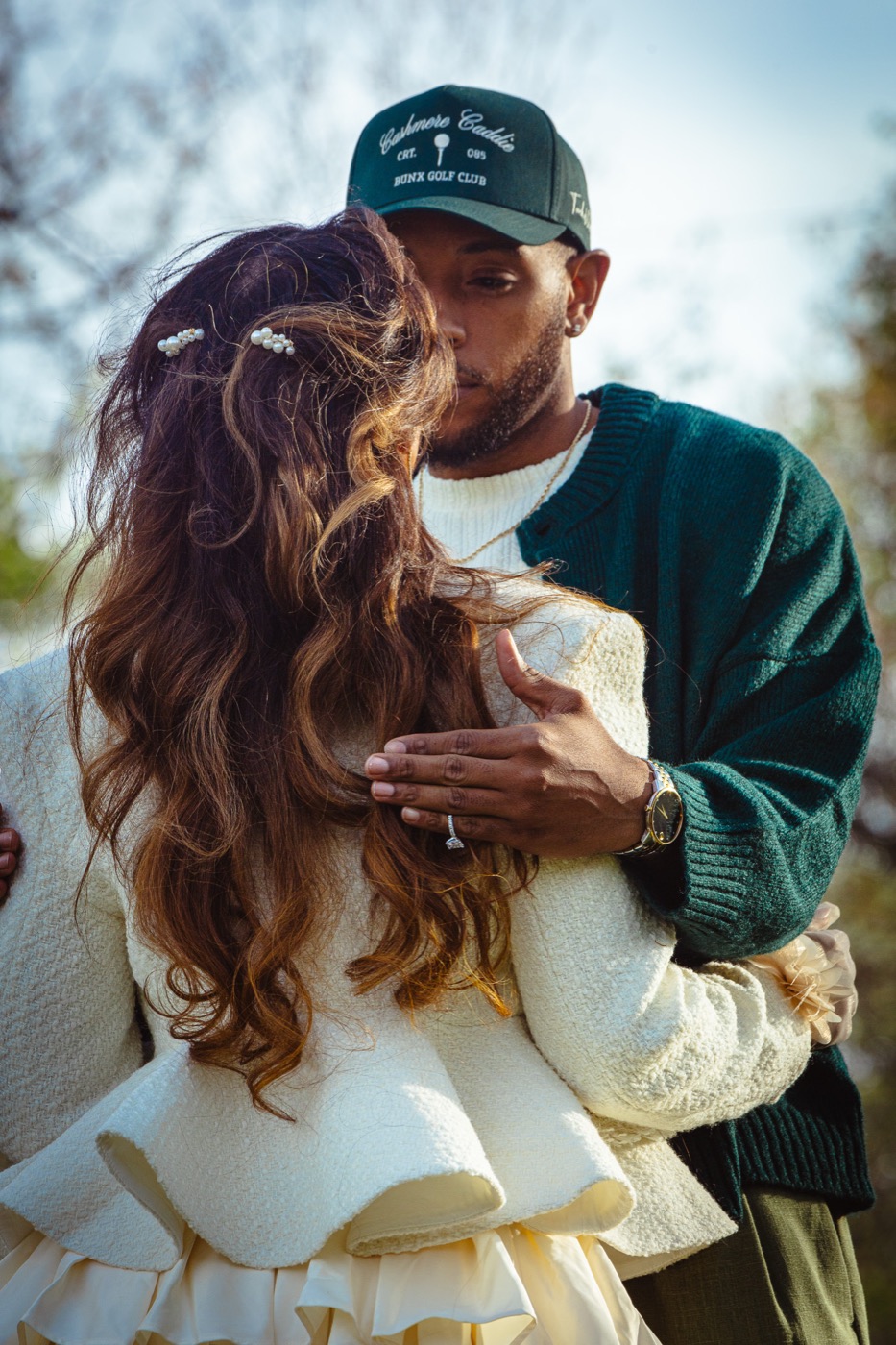 Jelani holding Kimberly close, his hand on her back showing her engagement ring